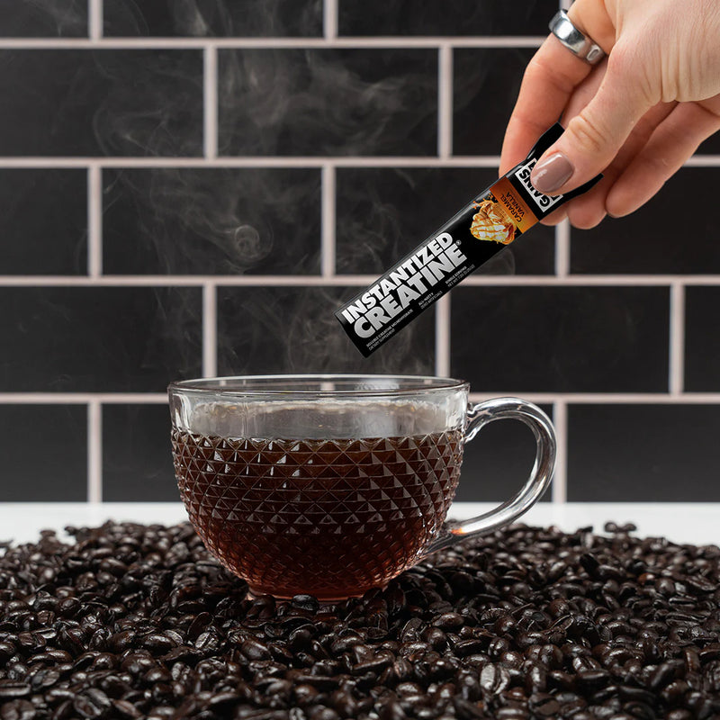 Instantized creatine caramel vanilla being poured into a hot cup of coffee. 